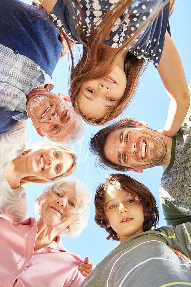 Familie mit drei Generationen steht im Kreis